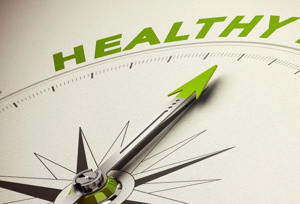 A compass needle pointing towards the word 'HEALTHY'.