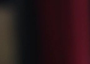 Abstract blurred image with dark and reddish tones.