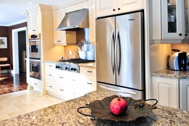 cream colored kitchen cabinets with granite counter top and stainless steel appliances