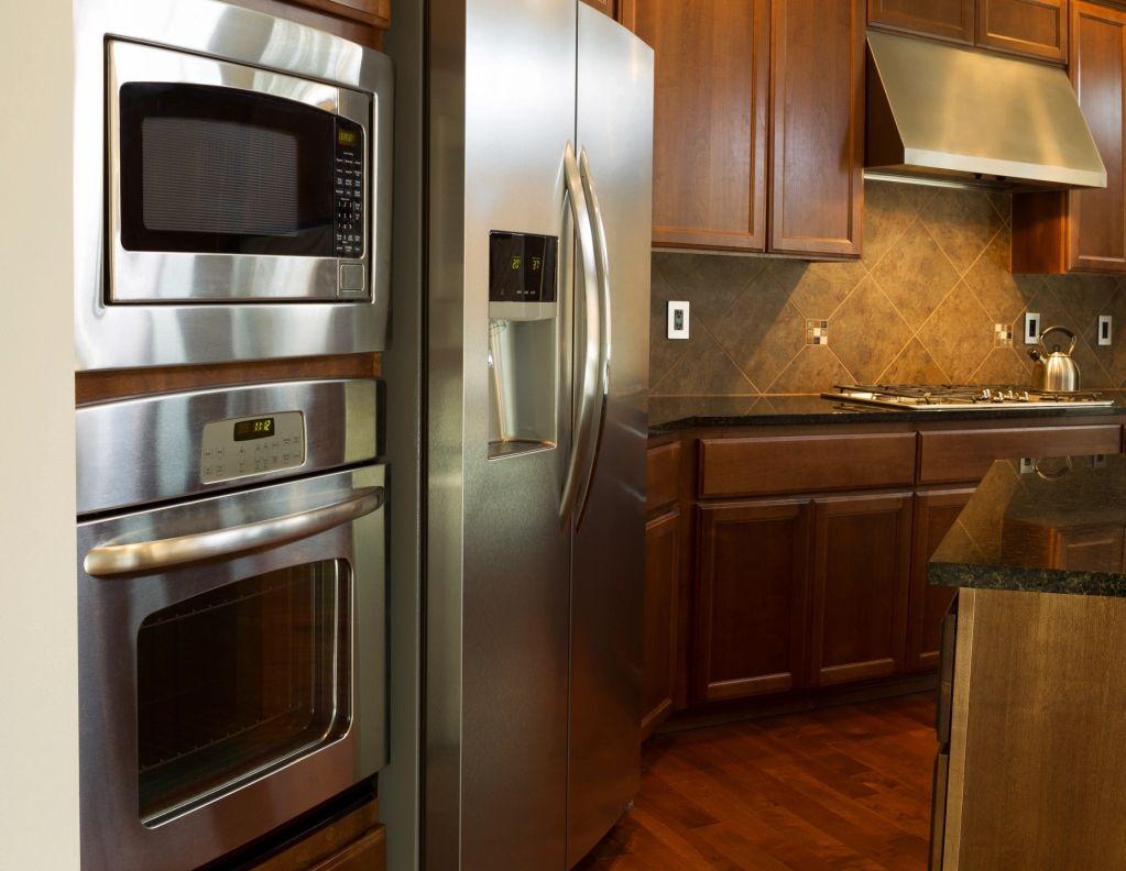 Modern kitchen with stainless steel appliances and wooden cabinets.