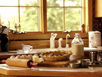 Rustic kitchen scene with freshly baked pie and baking ingredients.