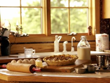 Rustic kitchen scene with freshly baked pie and baking ingredients.