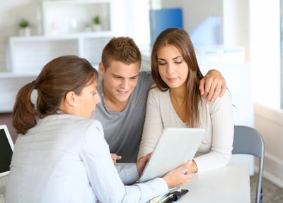 "Abrams Insurance: Advisor guiding young couple on policy details."


