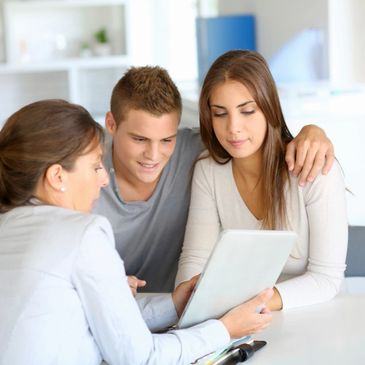 Three people sitting and looking at the laptop