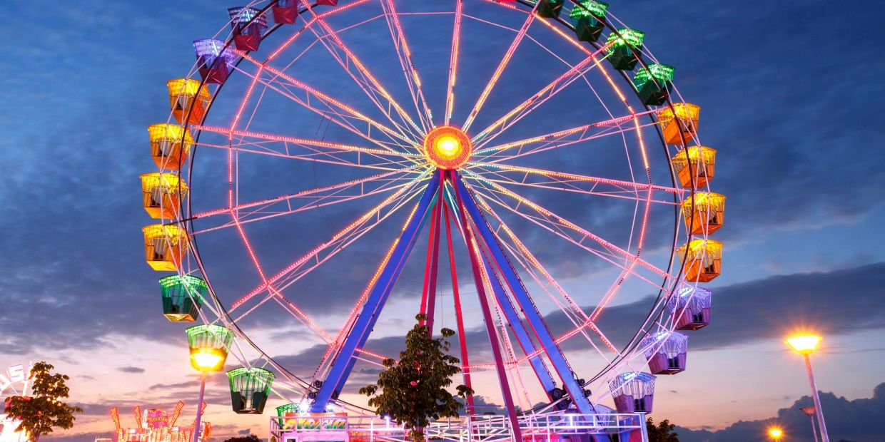 Colorful Ferris wheel lit up at dusk.