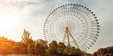 Uma grande roda-gigante contra um céu claro ao pôr do sol.