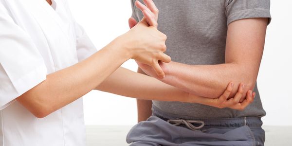 physiotherapist mobilizing a patients left wrist into extension