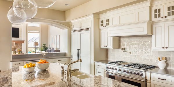 Luxury granite countertops in a Denver kitchen remodel with white cabinetry and modern lighting