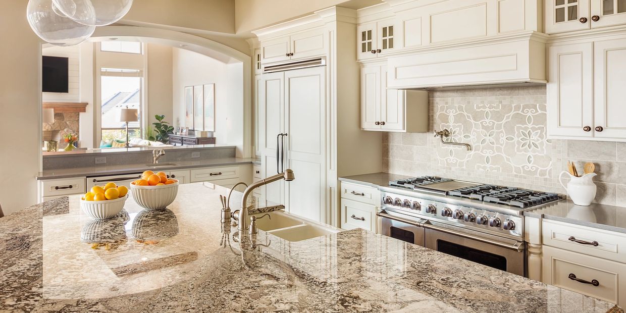Bright modern kitchen with granite countertops and white cabinetry.
