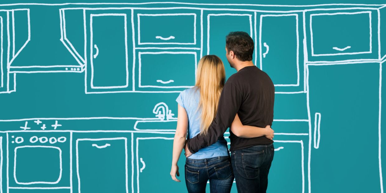 Couple imagining a kitchen design on a blue wall.