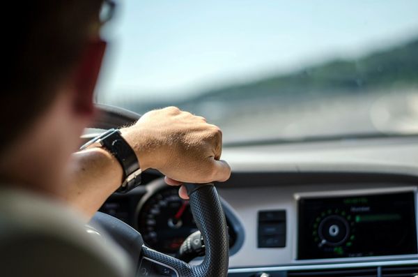 Man with hand on steering wheel