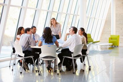 A group of people siting on a round table 