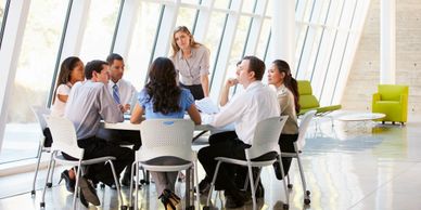 A group of business people, sitting around a table having a discussion.