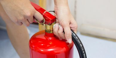 Pulling the pin on a portable fire extinguisher