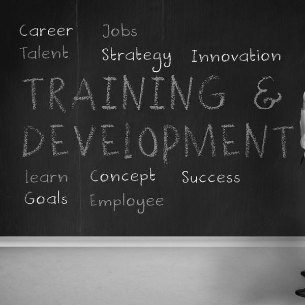 Training & Development benefits and outcomes documented on a blackboard