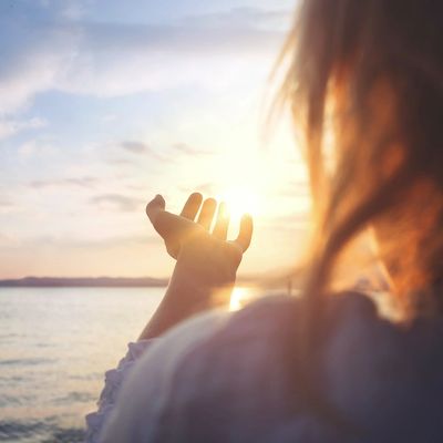 a photo of a woman watching the sunset over the ocean