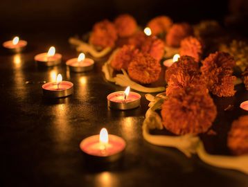 Lit candles and marigold flowers creating a warm, festive ambiance.