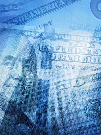 Collage of U.S. currency and a tall building with blue overlay.