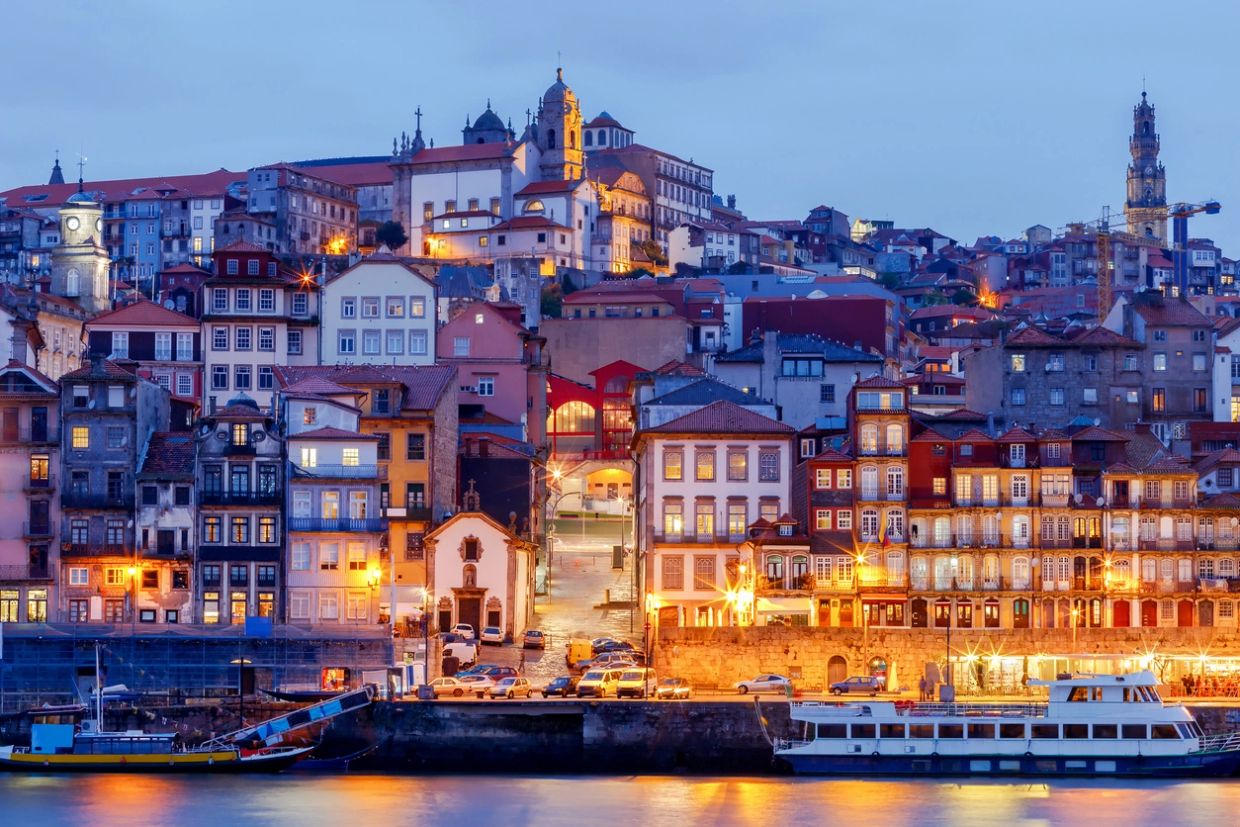 Colorful buildings and boats by the waterfront at dusk.