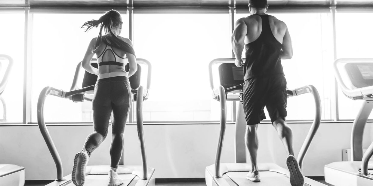 a man and woman running on treadmill