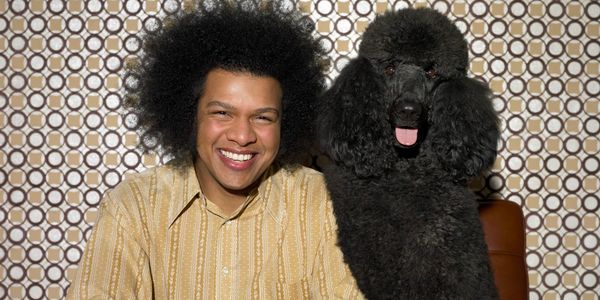 Man and black poodle dog sitting together