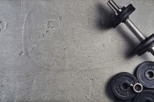 Dumbbell and weight plates on concrete floor.
