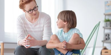 Adult Psychologist talking to a young child (boy)