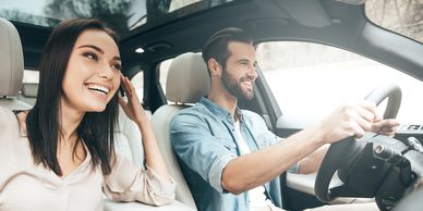 A happy couple enjoying a car ride together on a sunny day.