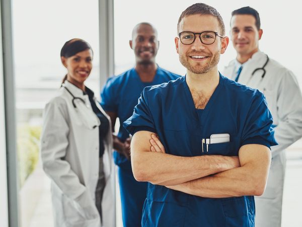 Smiling healthcare professionals posing confidently in a bright medical facility.