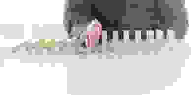 A man's hand between wooden blocks which are standing on their side.