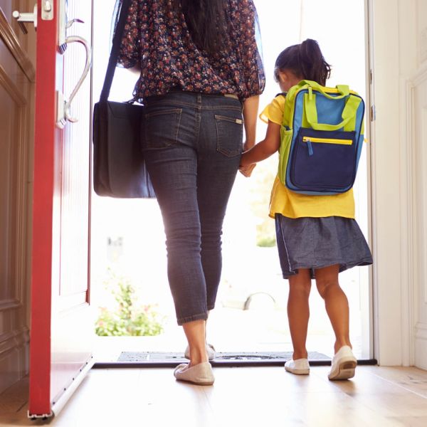 Mother and daughter holding hands, walking out the door.