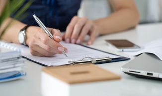 Image of woman writing with pen in her right hand