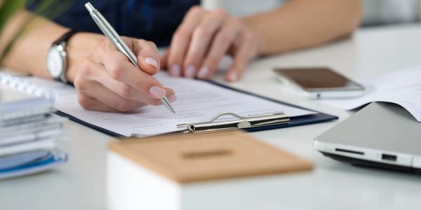 woman writing on clipboard