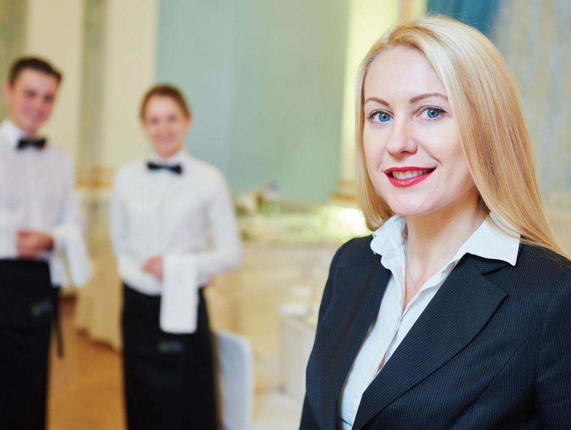 restaurant manager with servers in the background