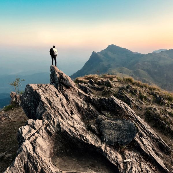 Hiker standing on top of peak at dawn