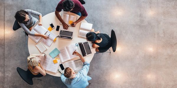 Group of students studying at a round table. 