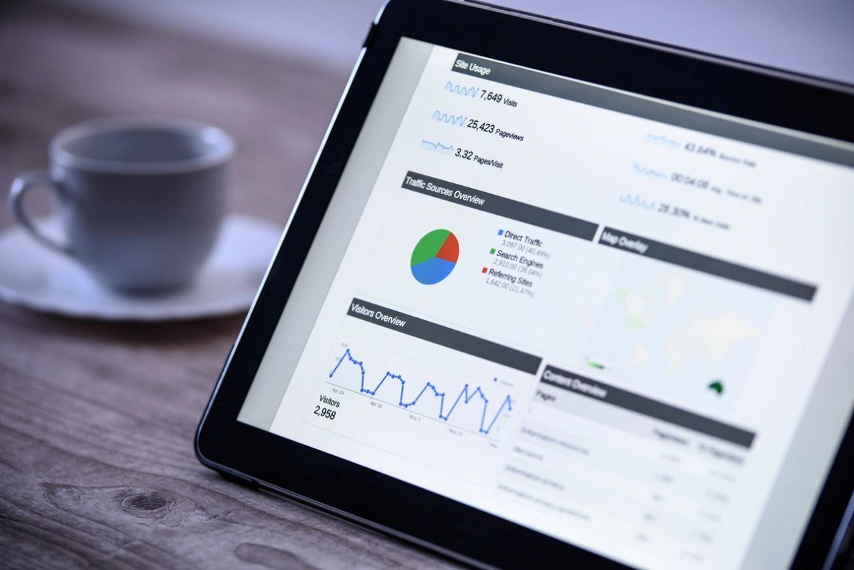Tablet displaying website analytics with a coffee cup in the background.