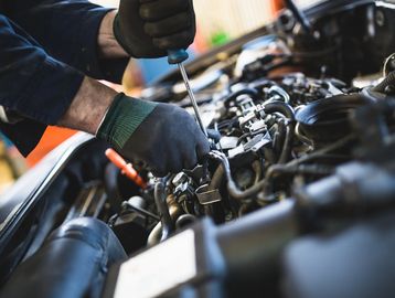 Mechanic working on an engine with tools 