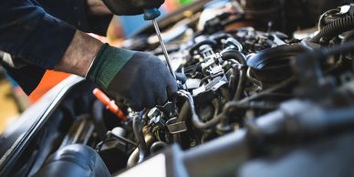 Auto repair technician securing hoses in engine compartment