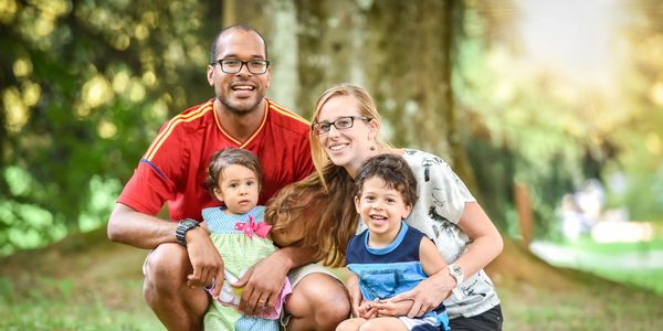 A family posing for a picture in a park.