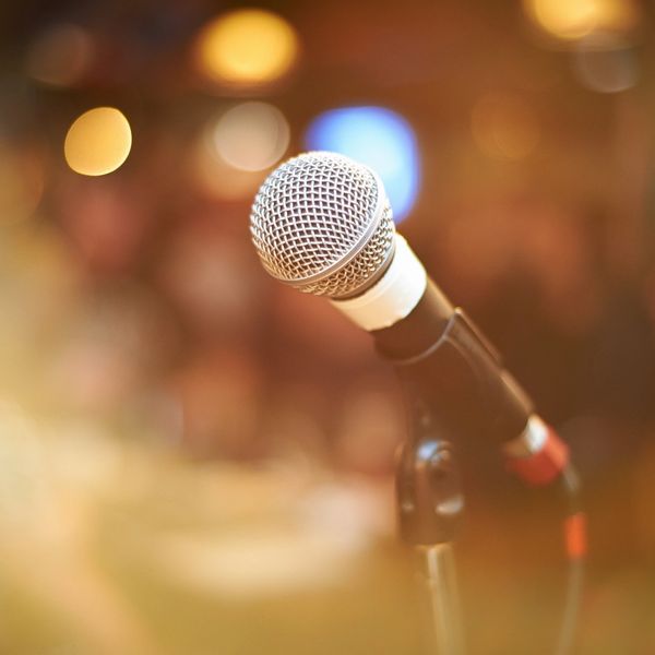 Close-up of a microphone with blurred background lights.