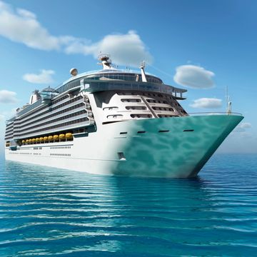 Large cruise ship sailing on calm blue ocean under a clear sky.