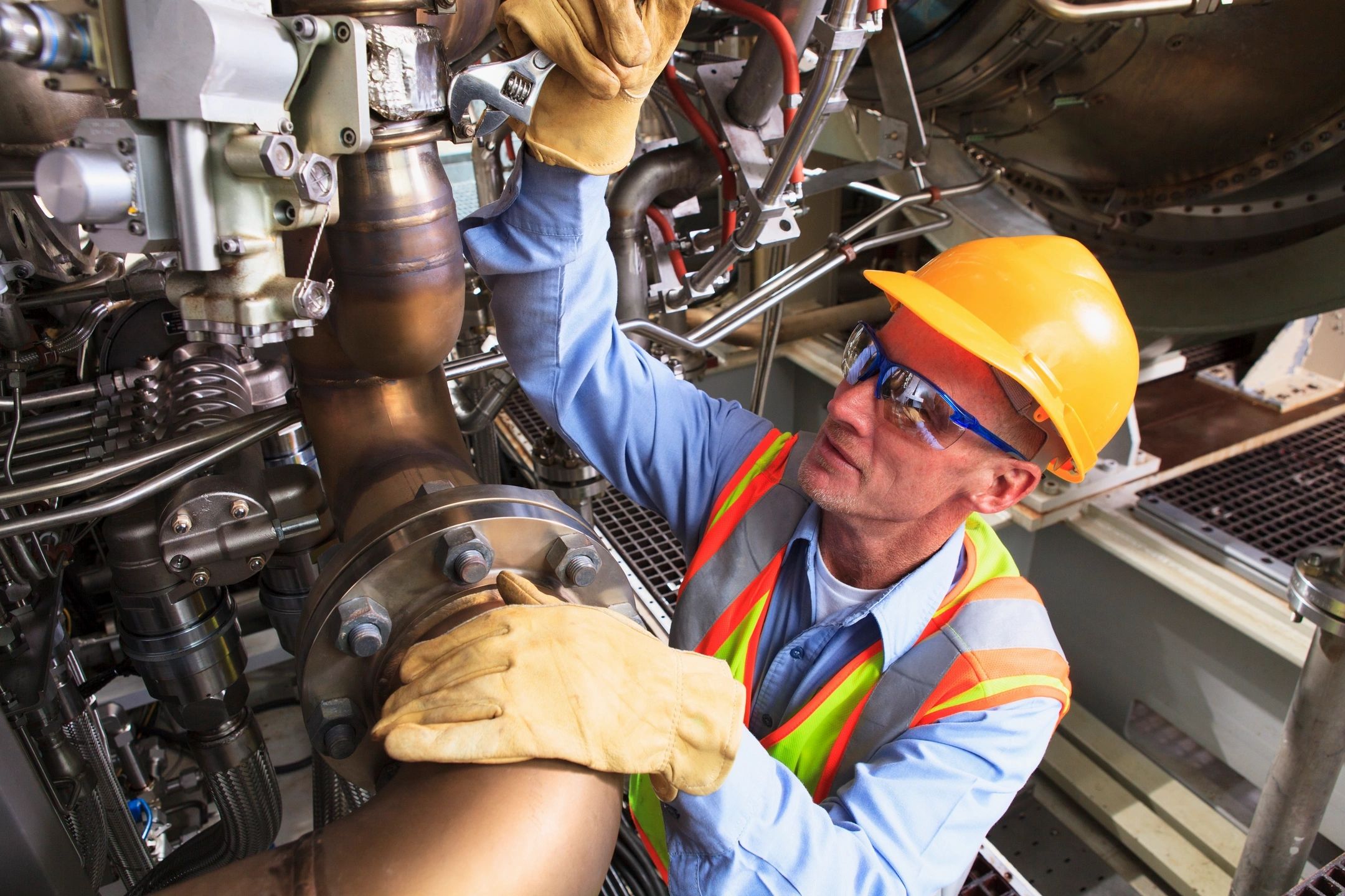 Millwright mechanic working on a machine using a wrench