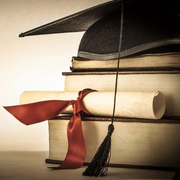 Graduation cap, diploma, and books symbolize academic achievement.
