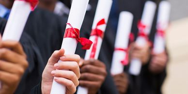 Group of people graduating holding their degrees.