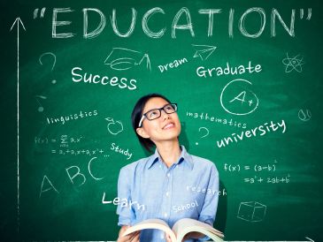 Student looking up at education-themed words on a chalkboard.