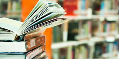 stack of books in library with open book on top