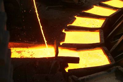 Molten metal being poured into molds in a foundry.