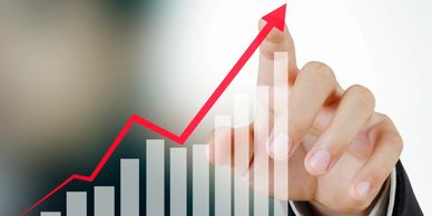 Hand drawing an upward financial growth chart.