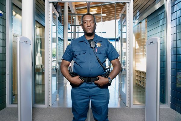 Security guard standing at a building entrance.